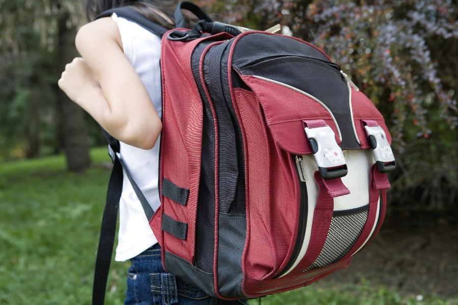 Mädchen mit schwerem, großen Rucksack - Trolleys als Schulranzen sind Alternative