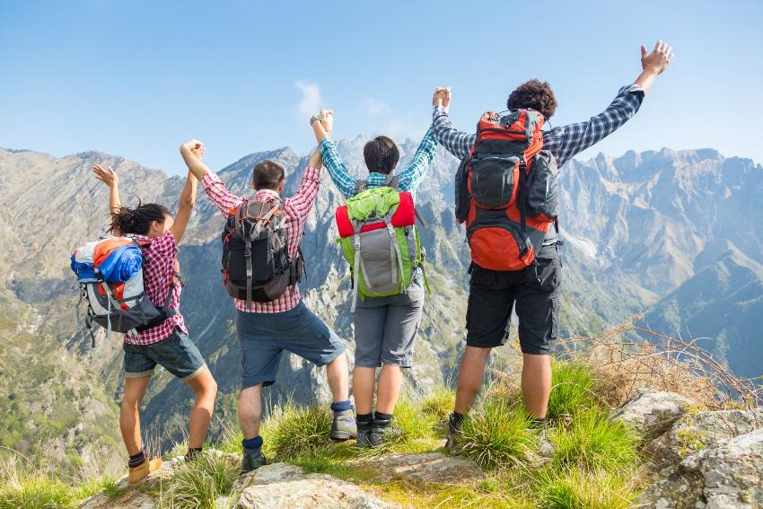 Gruppe junger Wanderer auf einem Berggipfel - Hochwertige Wanderrucksäcke sind wichtig