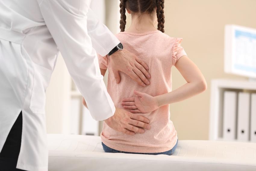 Mädchen mit Rückenschmerzen beim Arzt 