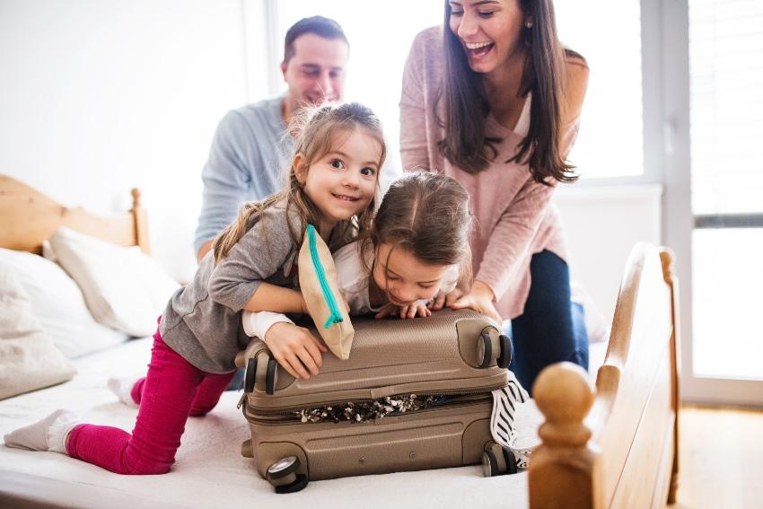 Familie packt einen übervollen Koffer