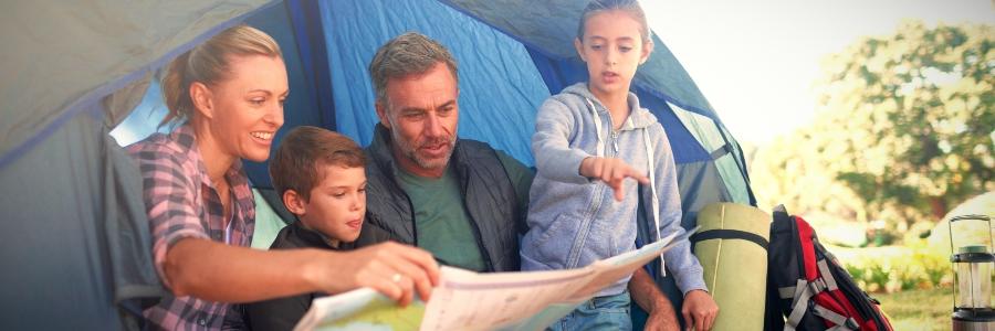 Familie im Zelt schaut eine Karte an