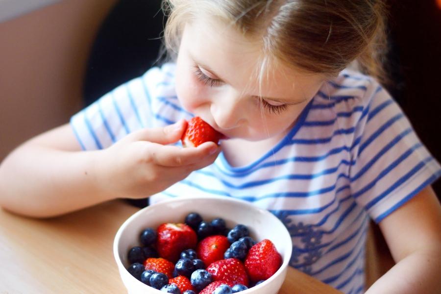 kind-isst-erdbeeren-und-heidelbeeren sinneswahrnehmung-bei-kindern-foerdern