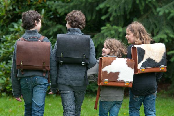 Kinder mit historischen Schulrucksäcken - die Geschichte der Schultasche