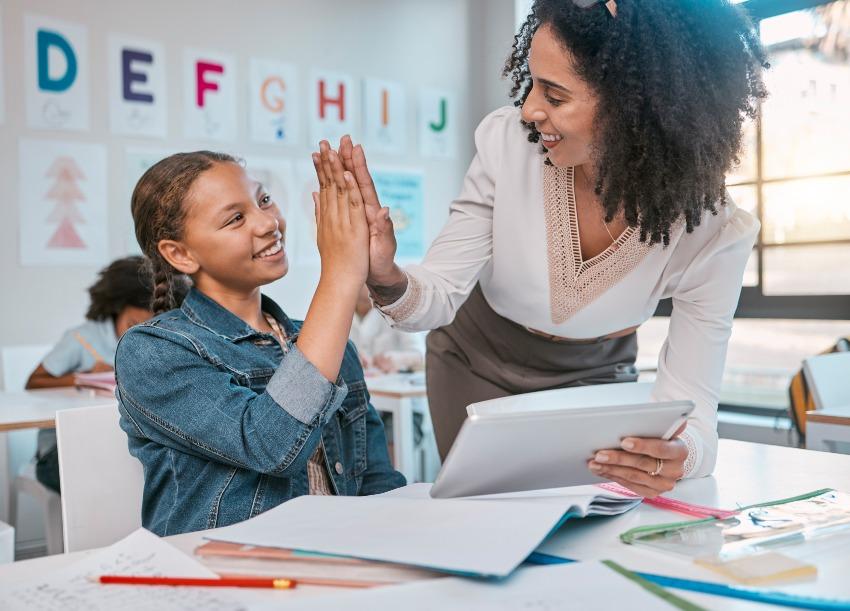 Schülerin und Lehrerin machen "High Five" - Kind hat Schulstress